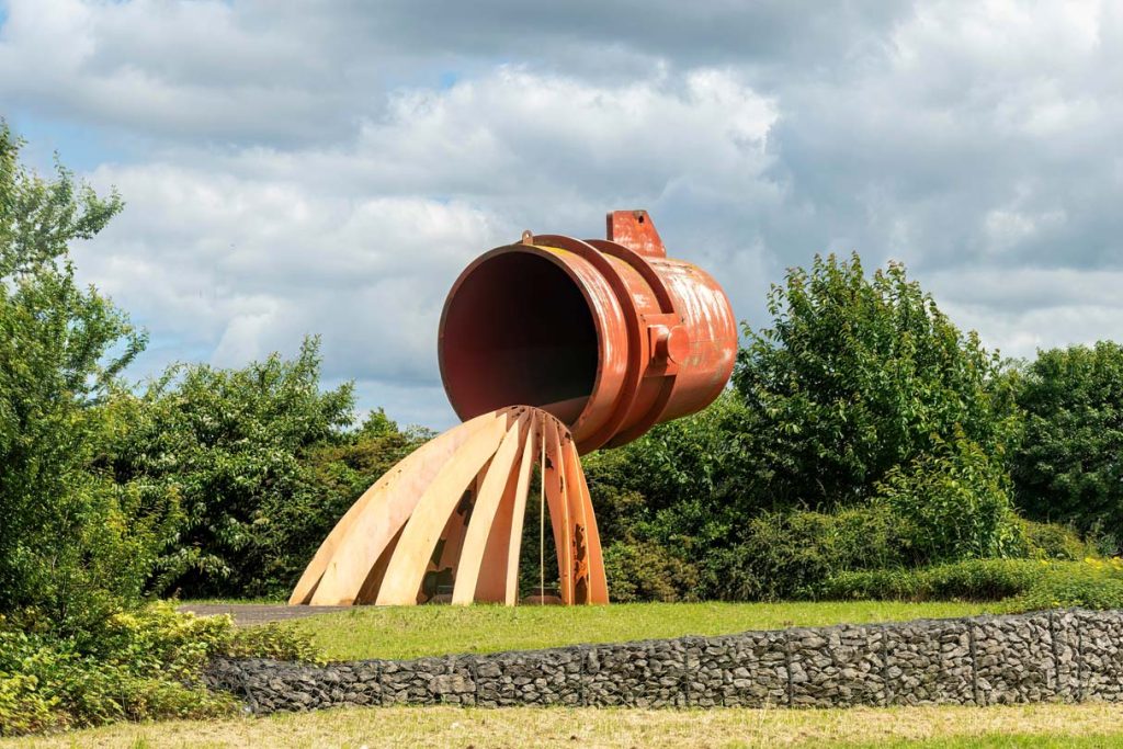Middlesbrough South Bank, Sculpture Ladle of Steel by Steve Tomlinso depicting a steel ladle pouring steel into a mould